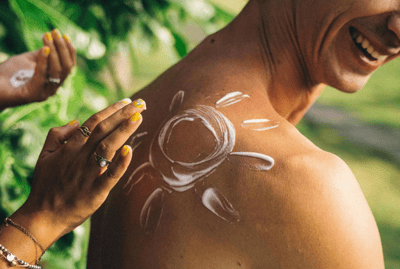 Sonnencreme in Sonnenform auf einer Schulter